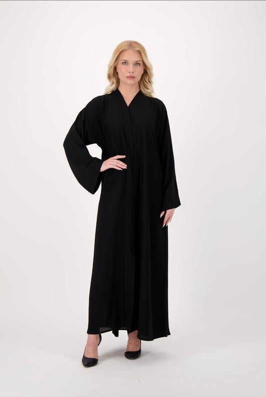 Front-opening black abaya made from soft, flowy Nida fabric, featuring a button-down design, loose fit, and full-length sleeves, worn by a model and displayed against a neutral background.